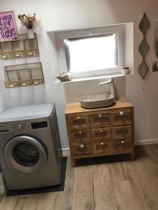 a laundry room with a washing machine and a window at La loc donvillaise in Donville-les-Bains