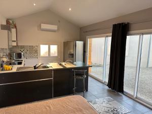 a kitchen with a black counter and a refrigerator at Dépendance de 45m2 à louer in Saint-Vite