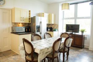 a kitchen with a table with chairs and a refrigerator at Llety in Criccieth