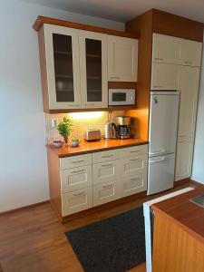 a kitchen with white cabinets and a white refrigerator at Finngland I in Rovaniemi