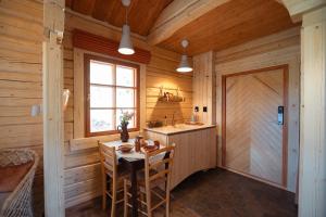 a kitchen with a table and a door in a room at Forest Cabin Ainola with Lake View next to Nuuksio National Park in Otalampi