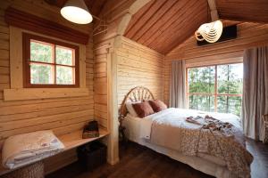 a bedroom with a bed in a log cabin at Forest Cabin Ainola with Lake View next to Nuuksio National Park in Otalampi