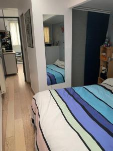 Un dormitorio con dos camas y un espejo. en Appartement Cosy tout équipé, en Colombes
