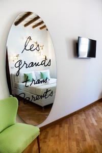a room with a round mirror and a green chair at PgrHome Luxury Apartments Parione in Rome
