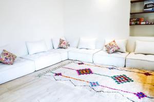 a living room with a white couch with a rug at Villa contemporaine - 6 chambres - piscines et jacuzzi in Marrakech
