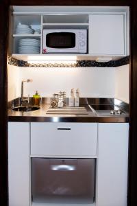 a kitchen with a stove and a microwave at PgrHome Luxury Apartments Parione in Rome