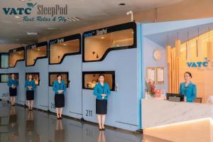un grupo de mujeres frente a un muro en VATC Sleep Pod Terminal 1, en Noi Bai