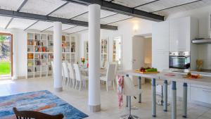 a kitchen with white columns and a table and chairs at VILLA ARDENTE 12&1, Emma Villas in Bellante
