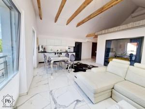 a living room with a white couch and a table at P6 White Line 55 in Pisz