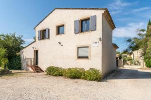 Casa blanca grande con ventanas y entrada en L'ensemble du gîte de Tante Berthe, en Camaret-sur-Aigues