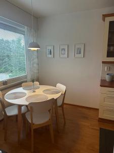 a dining room with a white table and chairs at Finngland I in Rovaniemi +7 photos