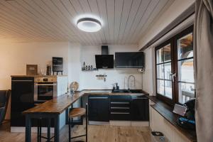 a kitchen with black cabinets and a wooden counter top at Apartment am Annaweiher in Hinterweidenthal