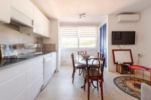 a kitchen with white cabinets and a table and chairs at Casa Colomer in Cadaqués