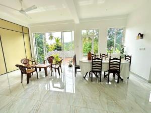 a dining room with a table and chairs at Valentine's Lodge in Ampitiya
