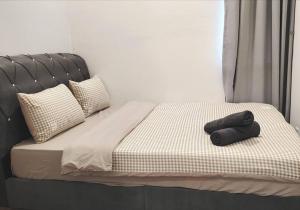a bed with a black headboard and two towels on it at GM B-1205 TWO BEDROOMS Cozy Netflix BySTAY in Iskandar Puteri +53 photos
