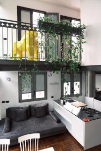 ein Wohnzimmer mit einer Couch und einigen Fenstern in der Unterkunft ComeCasa Terraced Apartment in Porta Romana in Mailand