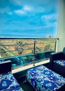 a room with a balcony with a view of the ocean at Luxueux Appartement ensoleillé vue sur mer in Pont Blondin