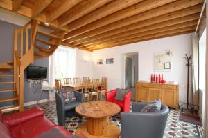a living room with a couch and a table at LA FERME DE LONGUES maisons spécialisées pour les familles avec jeunes enfants in Longues-sur-Mer