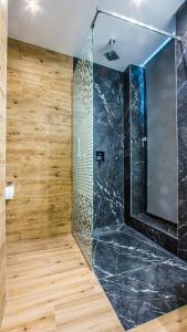 a bathroom with a large shower with a glass wall at Central Apart Hotel in Bucharest