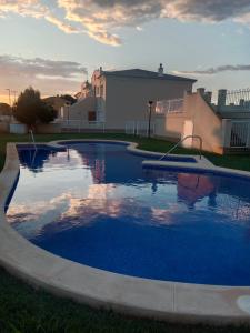 a large swimming pool in a yard with a building at Apartamento a 200m Playa Santa Anna in Denia