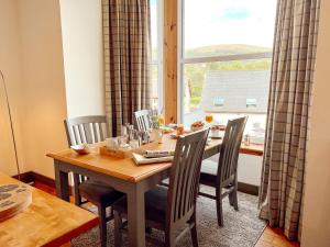 a dining room with a table and chairs and a window at Loch Ness Gatehouse Apartments in Fort Augustus +31 photos