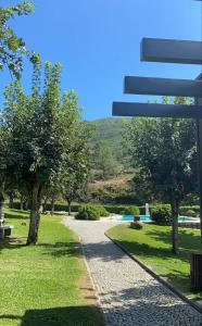 a path in a park with trees and a hill at Casa da Carqueija in Valezim