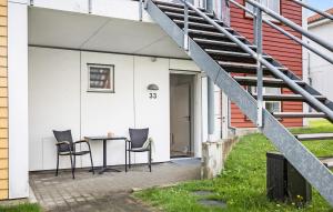 a patio with a table and chairs next to a building at Gudhjem Søpark Lejl 33 in Gudhjem