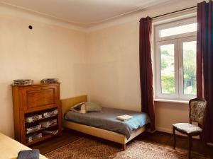 a bedroom with a small bed and a window at LA MARIEFACTURE - Comme chez le Baron in Saint-Avold