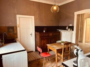a kitchen with a table and a table and chairs at LA MARIEFACTURE - Comme chez le Baron in Saint-Avold