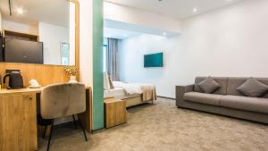a room with a bed and a couch and a television at Central Apart Hotel in Bucharest +51 photos