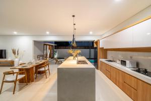 an open kitchen and dining room with a table and chairs at Stunning 2BDR Villa with Private Pool in CANGGU in Canggu