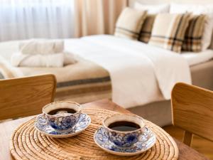 two cups of coffee on a table in a bedroom at FLH Boutique Studio in Warsaw
