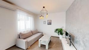una sala de estar con un sofá y una mesa en SALAN Apartman Sereď, en Seredʼ