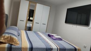 a bedroom with a bed with a tv and towels at Nova Panorama in Vrdnik
