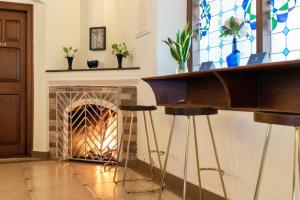 ein Kamin in einem Wohnzimmer mit Kamin in der Unterkunft SaffronStays Biccode Woodside Heritage in Belūr