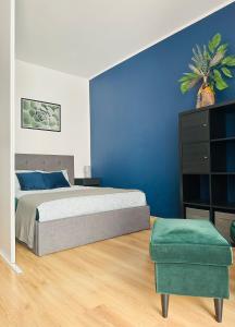 a bedroom with a bed and a blue wall at Małe Garbary 8 Apartment in Poznań