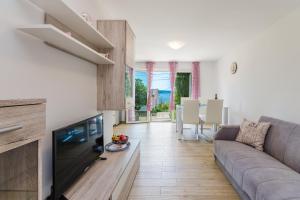 ein Wohnzimmer mit Sofa und Fernseher in der Unterkunft Leng in Dramalj