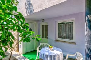 eine Terrasse mit Tisch und Stühlen und einem Fenster in der Unterkunft Leng in Dramalj