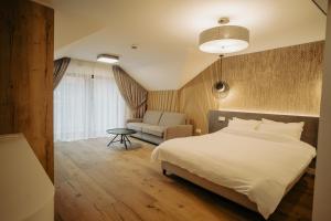 a bedroom with a white bed and a couch at Zen Den in Braşov