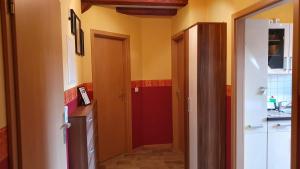 a hallway with a red door in a kitchen at Ferienwohnung im Gutshof Direkt gegenüber dem Schloss, Rhododendronpark mit Terrasse und WLAN in Kromlau +27 photos