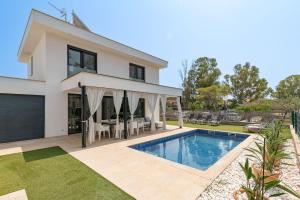 a villa with a swimming pool in front of a house at Beach Villa Cosins 1 Mel by Sealand Villas in Alcudia