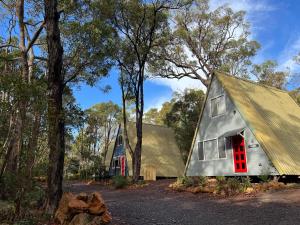 a barn with a red door in the woods at Hakea at Porongurup Chalets in Porongurup