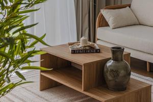 a wooden coffee table in a living room with a vase at Sahab - Rustic One BR Apt in Ḩiz̧āyib az Zānah
