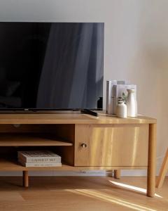 a tv on a wooden stand with a television on it at Sahab - Rustic One BR Apt in Ḩiz̧āyib az Zānah