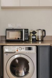 a kitchen with a microwave and a washing machine at Sahab - Rustic One BR Apt in Ḩiz̧āyib az Zānah +13 photos