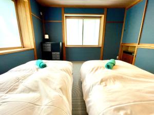 Postel nebo postele na pokoji v ubytování Ember Lodge - Hakuba
