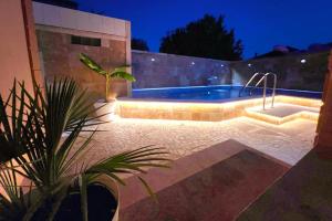 a swimming pool in a backyard at night at Aquamarine Jaz Montenegro in Budva