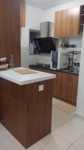 a kitchen with wooden cabinets and a counter top at Alanis Suites KLIA by Cotton Cloud in Sepang