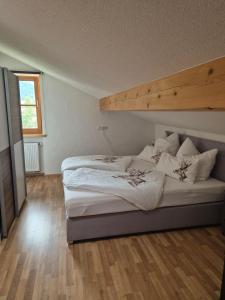 Un dormitorio con dos camas y suelo de madera. en Schmuckhäusl, en Reit im Winkl