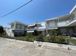 a row of white houses on a street at Palm Residential in Orfánion
